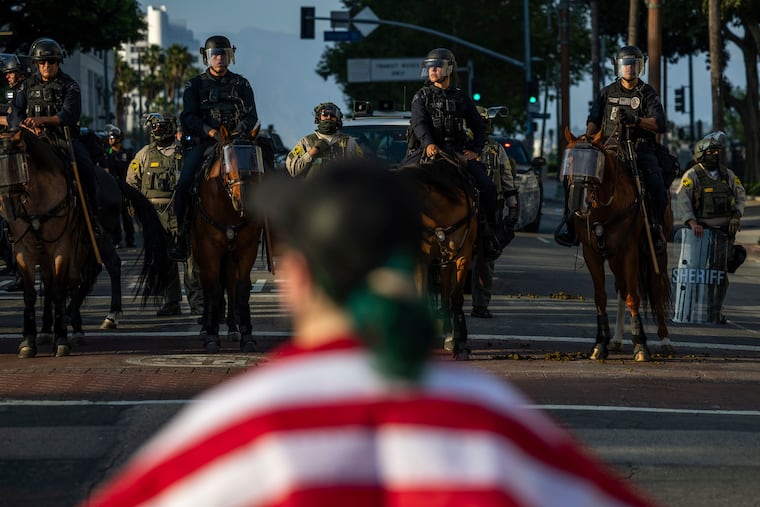 Police confront protesters outside City Hall in Los Angeles during protests over federal immigration enforcement raids on Wednesday, June 11, 2025.