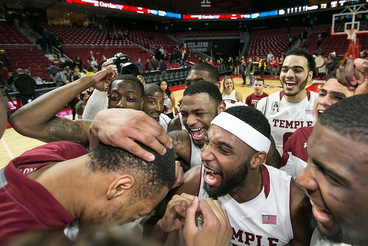 Temple players crowd around senior Devontae Watson as they celebrate their 72-62 victory over Memphis.