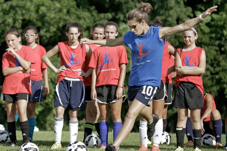 Carli Lloyd demonstrates the next shooting drill during the Carli Lloyd Day Camp at Universal Soccer Academy in Lumberton on July 18, 2015. (ELIZABETH ROBERTSON / Staff Photographer)