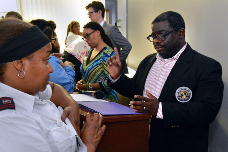 Eastern Academy Charter School Principal and CEO Omar Barlow (right) and COO Yvonne Turner address questions from Patricia Riley (left) and other student's parents during a meeting on Thursday evening August 8, 2019.