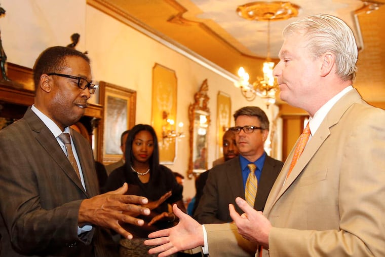 City Council President Darrell L. Clarke (left) shakes hands with union leader John "Johnny Doc" Dougherty at a fund-raiser.