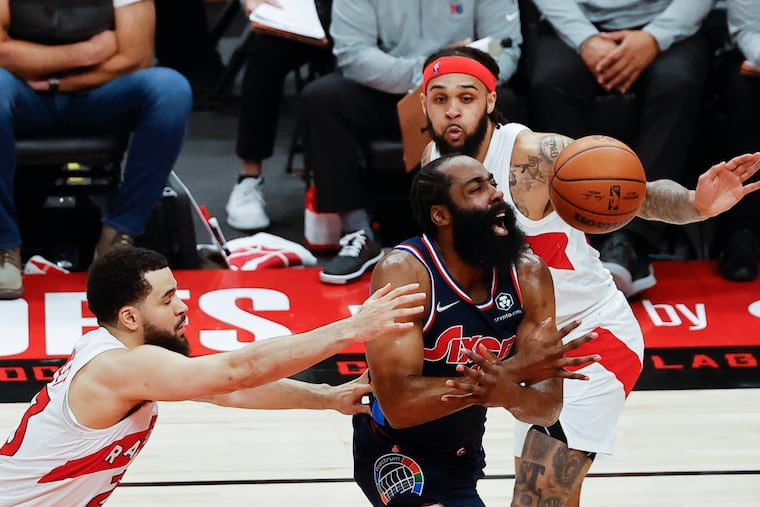 Sixers guard James Harden loses the basketball after getting fouled against Toronto Raptors guard Gary Trent Jr., (right) and guard Fred VanVleet in the second quarter during game four of the first-round Eastern Conference playoffs on Saturday, April 23, 2022 in Toronto.