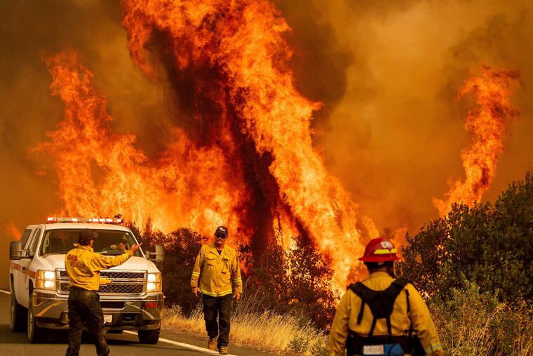 Flames from the LNU Lightning Complex fires leap above Butts Canyon Road in Lake County, Calif., on Sunday.