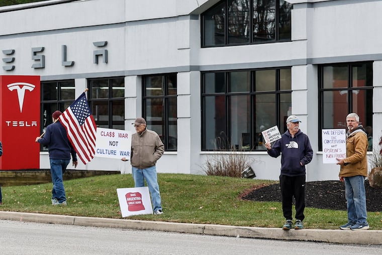 People protest Saturday at the Devon Tesla dealership in response to the company's shareholders awarding Elon Musk more than a trillion dollars.