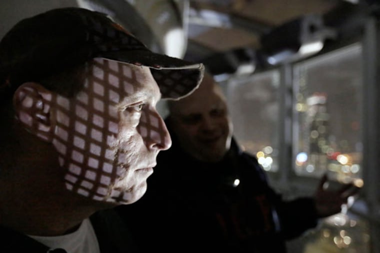 Olde City Paranormal members Glenn Orwan (left) and George Feinstein listen for clues in the City Hall tower during a recent mission. (ELIZABETH ROBERTSON / STAFF PHOTOGRAPHER)