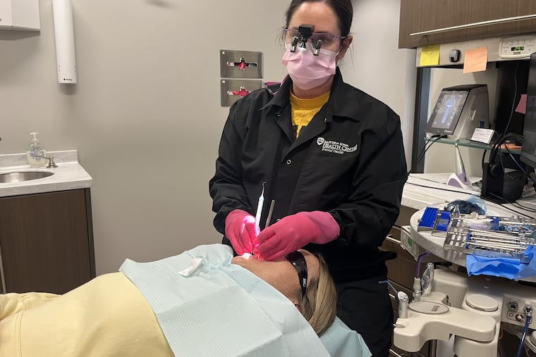 Dental hygienist Lexi Rusnak cleans a patient’s teeth at the Eastern Iowa Health Center in Cedar Rapids, Iowa, on March 26, 2026. (Tony Leys/KFF Health News)