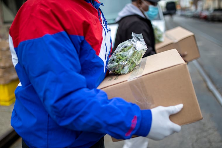 Families and residents in the area pick up boxes of packaged food from Philabundance in April.