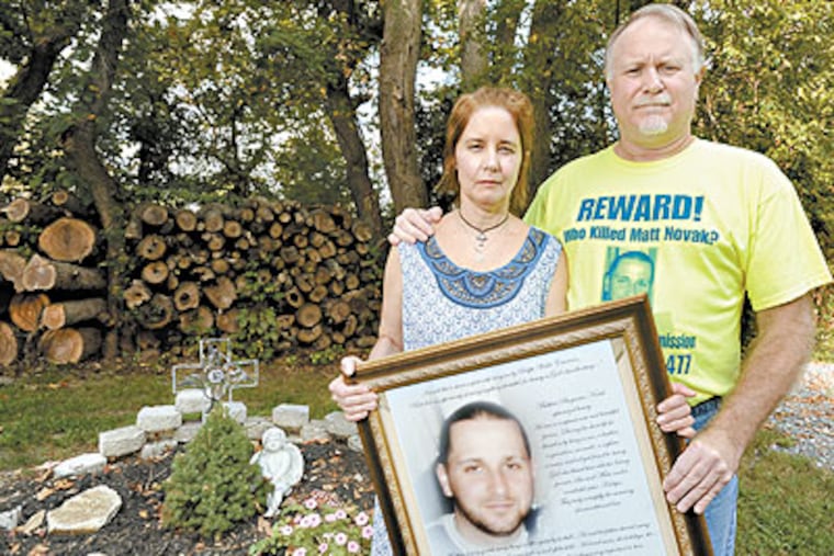 Sue and Matt Novak stand in front of a memorial garden holding a photo of their murdered son Matthew. Matthew was 24-years-old when he was killed at random in Philadelphia after watching the Puerto Rican parade in 2008. The Novaks are sponsoring a picnic on Saturday at Tall Pines Picnics and Retreat in Williamstown, NJ. (Clem Murray / Staff Photographer)