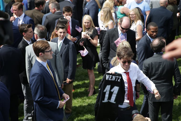 Tim Dagit of Chester Springs, Pa. holds a Wentz jersey and a small American flag as he walks through the crowd during the "Celebration of America" event at the White House in Washington, DC on June 5, 2018.