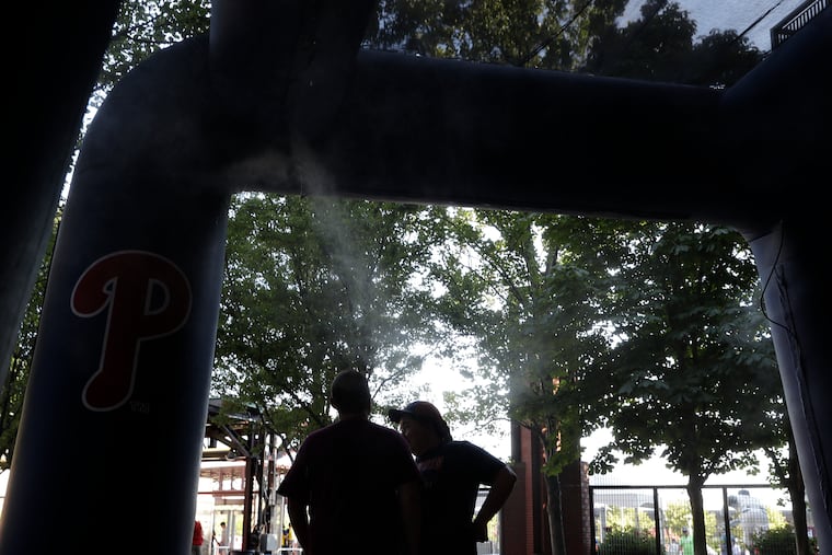 Phillies fans cool off standing in the spray mist tent at Citizens Bank Park before the played the Chicago Cubs on Saturday, July 23, 2022 in Philadelphia. The city has developed extensive plans for dealing with extreme heat.
