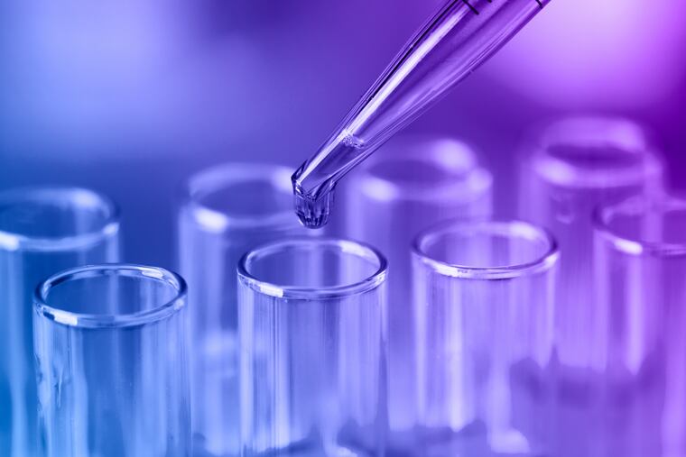 Test tubes with blue liquid water samples and pipette. Pipette dropping sample into test tube. Laboratory glassware, science laboratory research concept.