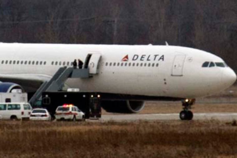 The Delta-Northwest Airlines plane N820NW is pulled back to the terminal at the Detroit Metropolitan airport in Romulus, Mich., after a passenger set off an explosive device Friday in a failed terrorist attack. (AP Photo/Carlos Osorio)