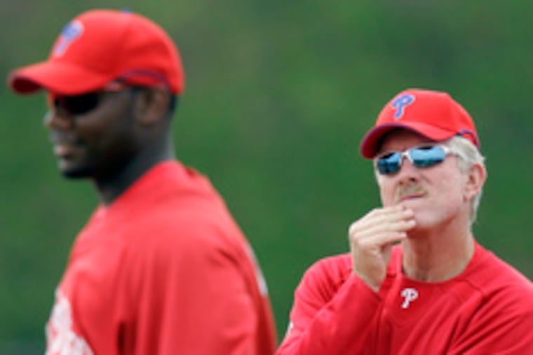Phillies great Mike Schmidt (right), in Clearwater as an instructor, watches Ryan Howard as he works on a drill.