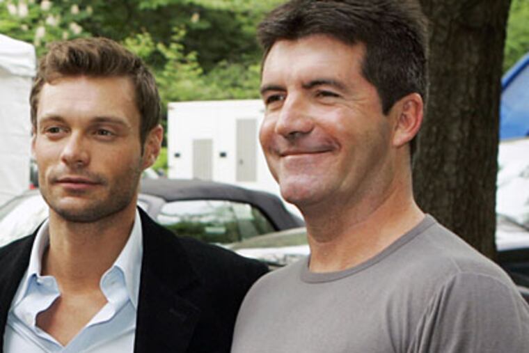 Is Ryan Seacrest (left) angling for Simon Cowell's job? (AP)