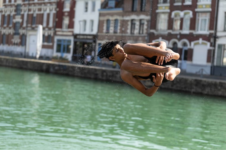 A young man jumps into the water in Lille, northern France, Monday June 22, 2026.