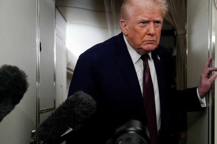 President Donald Trump speaks to reporters while in flight on Air Force One to Joint Base Andrews, Md., on Sunday.