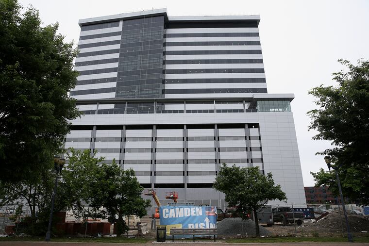 A banner reads "Camden Rising" outside the new high-rise office tower on the waterfront in Camden, N.J., on May 9, 2019. The project involved $245 million in tax breaks, including $79 million for NFI.