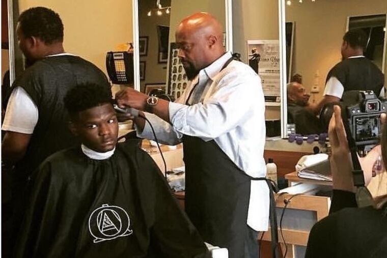 Byron Woods cuts a customer's hair at his Ohio barber shop in 2019.