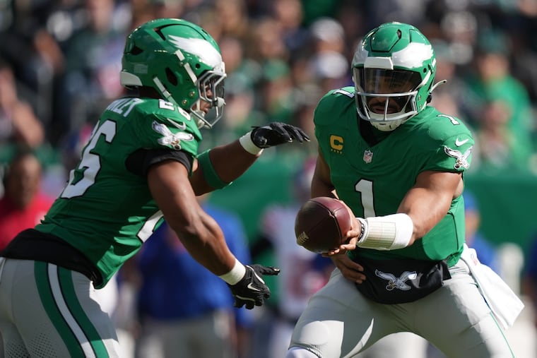 Eagles running back Saquon Barkley takes a handoff from Jalen Hurts on Sunday, when the team's running game came alive.