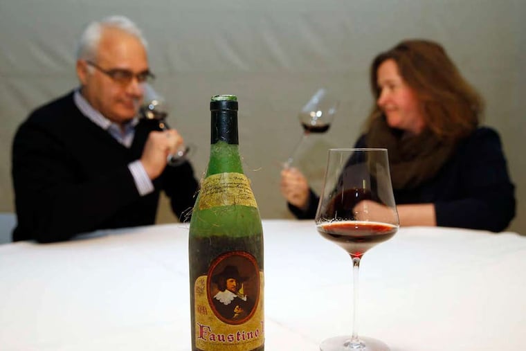 A bottle of the1964 Faustino I Rioja wine on display as Joe Canal's managers Dino Garistina (left) and Andrea Billick assess the wine at Joe Canal's in West Deptford on Friday, January 23, 2015. ( YONG KIM / Staff Photographer )