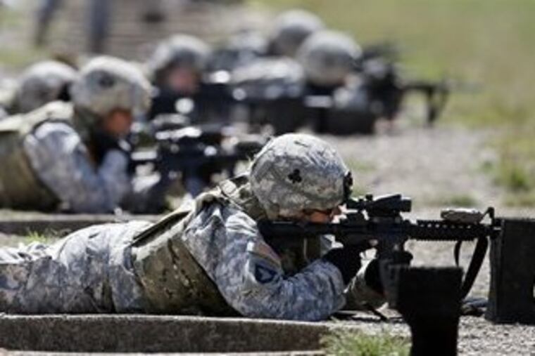 FILE - In this Sept. 18, 2012 file photo, female soldiers from 1st Brigade Combat Team, 101st Airborne Division train on a firing range while testing new body armor in Fort Campbell, Ky., in preparation for their deployment to Afghanistan. The Pentagon is lifting its ban on women serving in combat, opening hundreds of thousands of front-line positions and potentially elite commando jobs after generations of limits on their service, defense officials said Wednesday, Jan. 23, 2013. (AP Photo/Mark Humphrey, File)