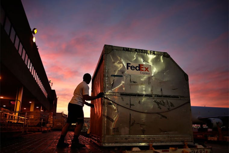 FILE - In this Monday, Dec. 2, 2013, file photo, Moulton Tuuoloaki prepares to load a container onto a FedEx cargo plane at the FedEx hub at Los Angeles International Airport in Los Angeles. Dozens of online subscription businesses in recent years have popped up that offer to ship boxes of goodies within a given niche or theme, like makeup or shoes, each month for $1 to about $50. Most often, the exact products remain a mystery until they’re shipped (AP Photo/Jae C. Hong)