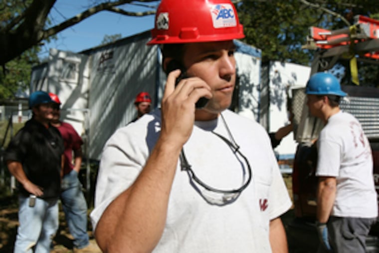 Christos Vasilarakis, a supervisor with Worth & Co., talks with the main office during a break in work installing HVAC systems at Lincoln University's student union building in Chester County.