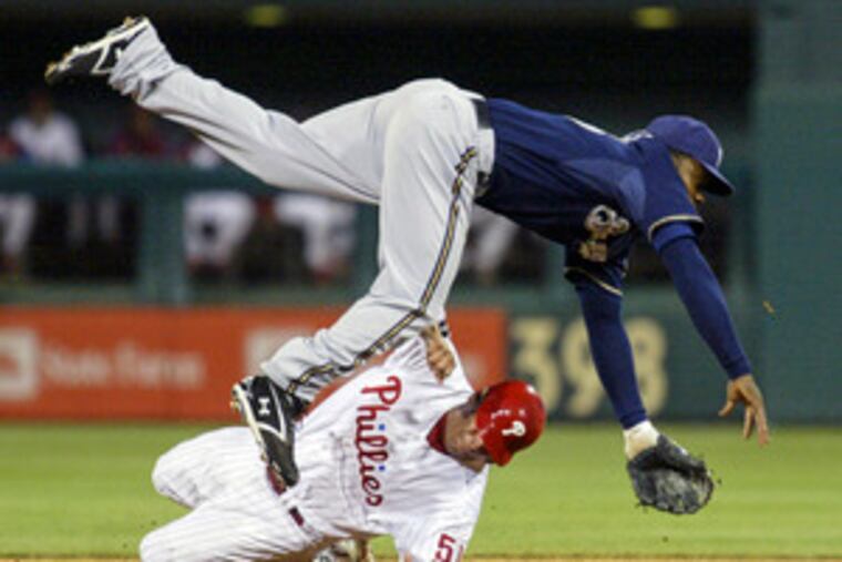 Carlos Ruiz tries to break up doubleplay, but Brewers' Rickie Weeks still was able to turn it.