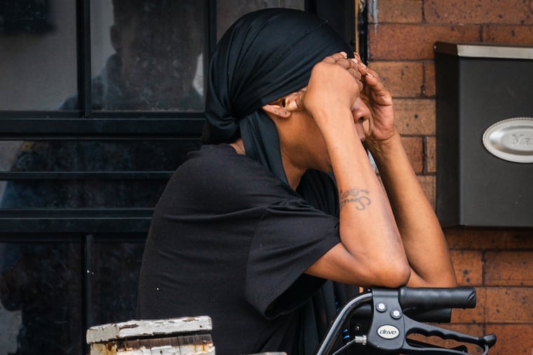 A woman on the porch of the home where police are investigating the fatal shooting of a 2-year-old.