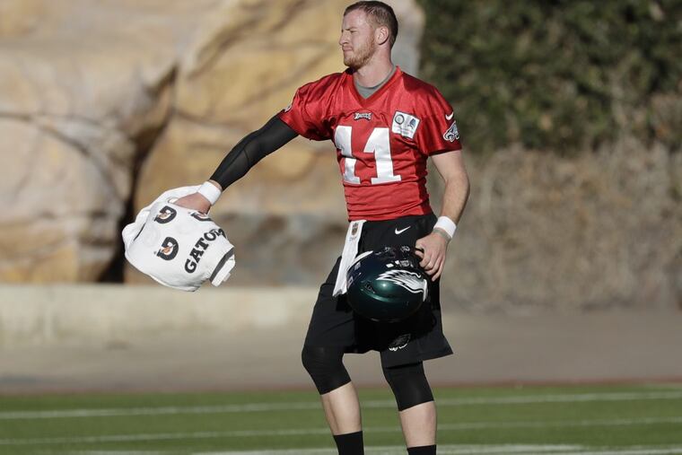 Eagles quarterback Carson Wentz catches a towel during team practice at Angel Stadium of Anaheim on Wednesday.
