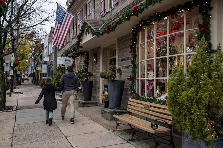 People walk by holiday decor outside Robertson's Flowers & Events in Chestnut Hill in November.