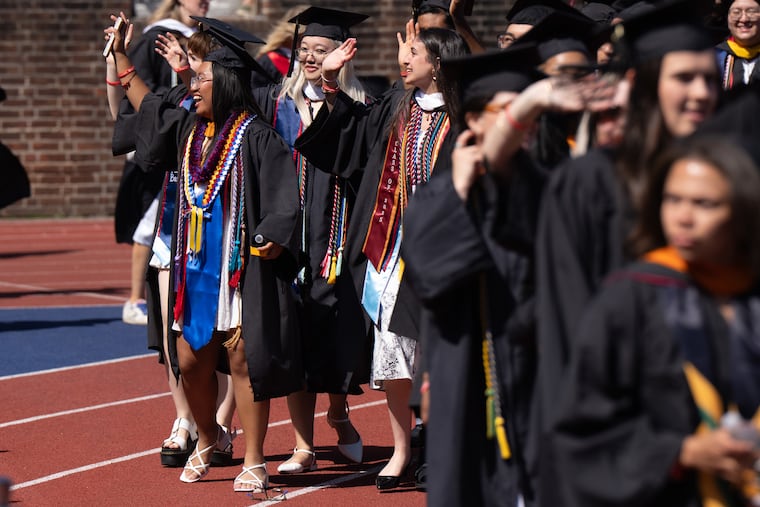 Kristel Rambaud, left, a nursing student, waves at people in the bleachers, at graduation at University of Pennsylvania's Franklin Field, in Philadelphia, May 19, 2025.