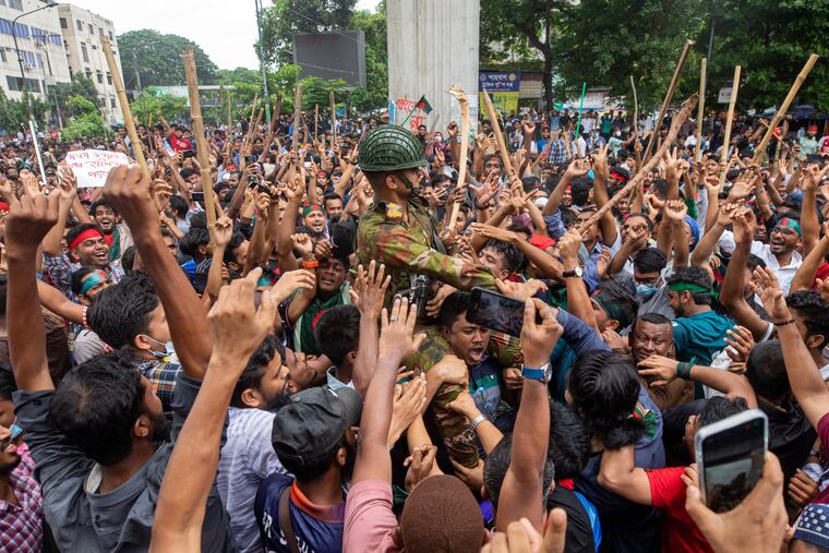 Protesters carry a member of the army on their shoulders as they celebrate Prime Minister Sheikh Hasina's resignation, in Dhaka, Bangladesh.