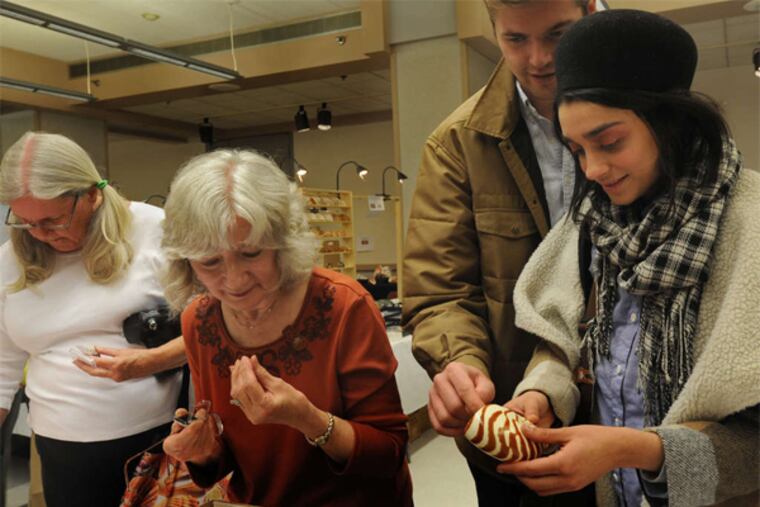 Alek Jaunzemis and Manna Pourrezaei (right) of Philadelphia look at a chambered nautilus as Evangeline Strafford of Reading shops.