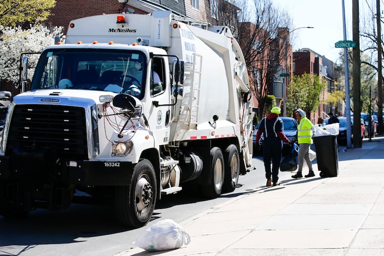 Philadelphia sanitation workers pick up trash along the 1100 block of Lombard Street. Labor Day will affect the pickup schedule.