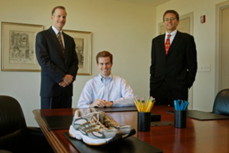 Colleagues (from left) Bill McSwain, Joe Doherty and Brad Barren carry their law firm's banner in the annual Chester County Bar Association's run.