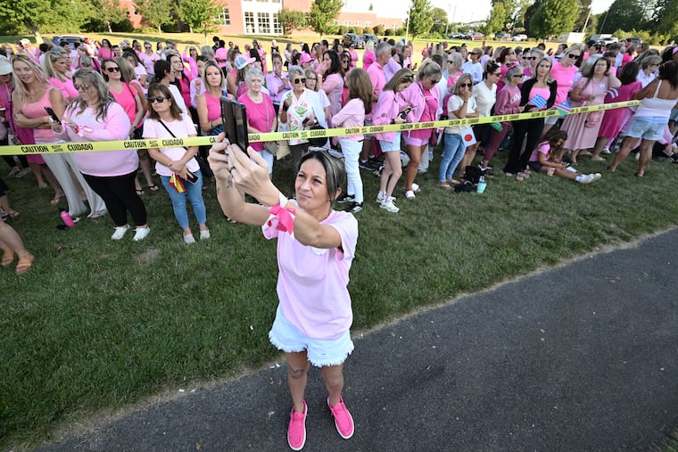 Aimee Breault of Acushnet, Mass., live-streams a demonstration in support of Lindsay Clancy outside Plymouth Superior Court, where Clancy is on trial in connection with the deaths of her three children, Thursday in Plymouth, Mass.