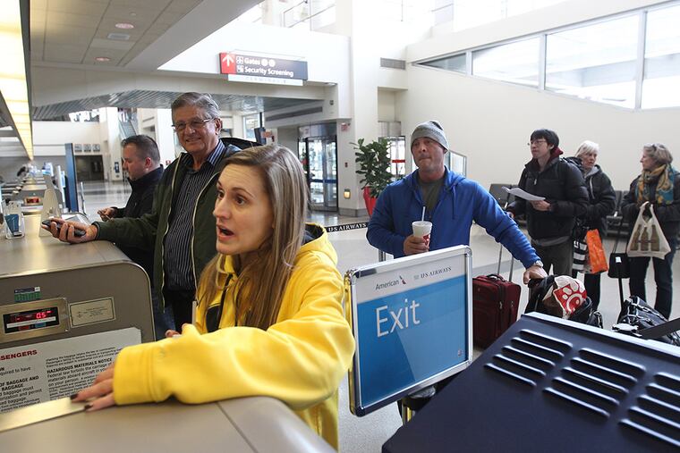 Dawn Lochner, of New Jersey, talks to the US Airways ticket agent about getting out of Philadelphia on Tuesday to a business meeting in Los Angeles on Jan. 27, 2015. There were no flights out of Philadelphia from US Airways on Tuesday except a night flight to Tel Aviv. ( Michael Bryant / Staff Photographer )