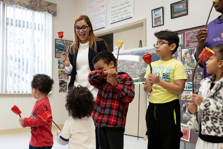 Councilwoman Felisha Reyes-Morton laughs with children at a community event last week at Camden Lutheran Housing Inc., where residents crafted roses and hearts out of reused materials to bring to their community garden in North Camden.