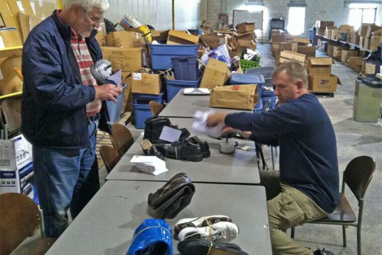 Ron Miller (left) and Steve Mannion, a volunteer from Downingtown, sort through some of the donations to the charity In Ian's Boots.