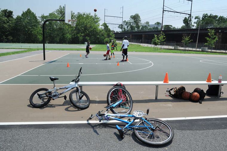 On the Seventh Street basketball courts in Chester, Zain Shaw, a coach and trainer, works with children. Many see the lessons learned there - both athletic and personal - to help in getting them out of the beleaguered city.