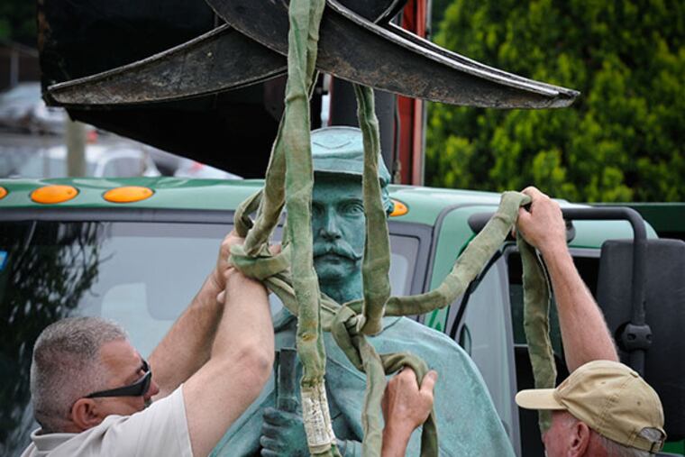 Willie Farrell, who carved the base for the "Silent Sentry," and Frank Rausch prepare the statue to be lifted in place at Laurel Hill Cemetery May 14, 2014. ( RON TARVER / Staff Photographer )