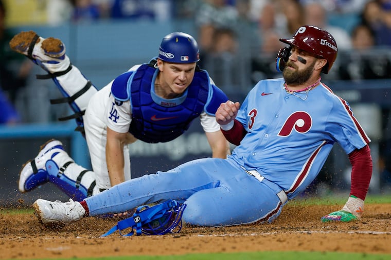 The Phillies' Bryce Harper is tagged out at home by Dodgers catcher Will Smith during Game 3 of the NL Division Series on Oct. 8, 2025.