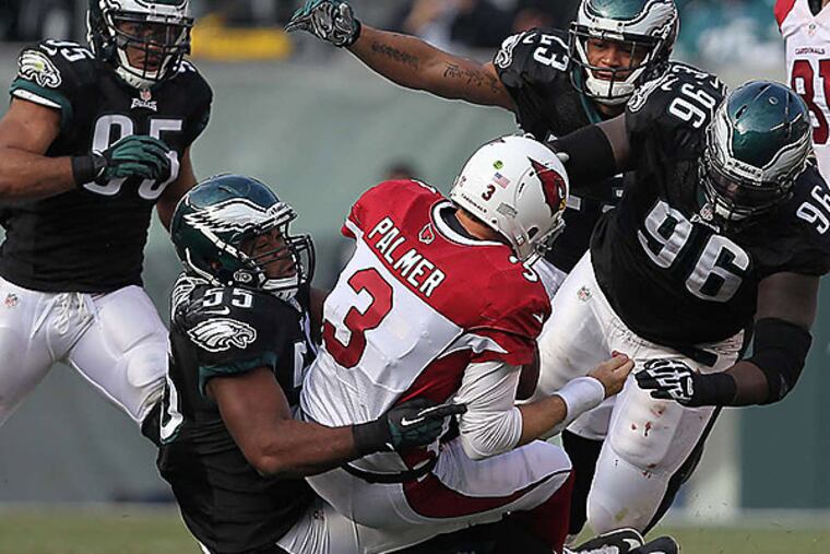 Eagles linebacker Brandon Graham sacks Cardinals QB Carson Palmer as (from left) Mychal Kendricks, Patrick Chung, and Bennie Logan close in. (David Maialetti/Staff Photographer)