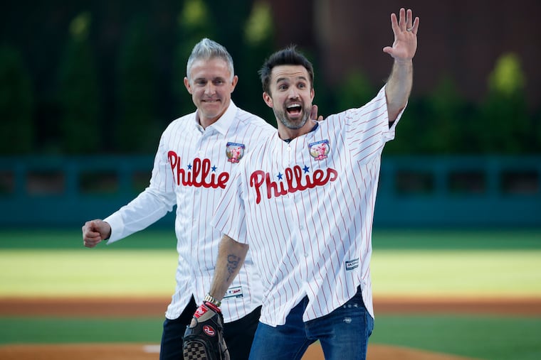 Actor Rob McElhenney (right) one of the creators of "It's Always Sunny in Philadelphia," reacts after catching a ceremonial first pitch from former Phillies player Chase Utley before a baseball game between the Phillies and the Miami Marlins on June 21, 2019.