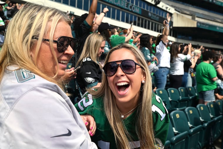 Madison Flythe (right), a senior at Clemson University, reacts with her mom Melinda Hall as former Eagle linebacker Jeremiah Trotter, Sr. arrives onstage at the Linc. Flythe was a college classmate of Trotter’s son Jeremiah Trotter Jr., who was recently drafted by the Eagles.