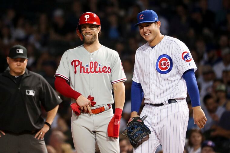 Bryce Harper (left) and the Phillies will try to split the series with Anthony Rizzo (right) and the Cubs.