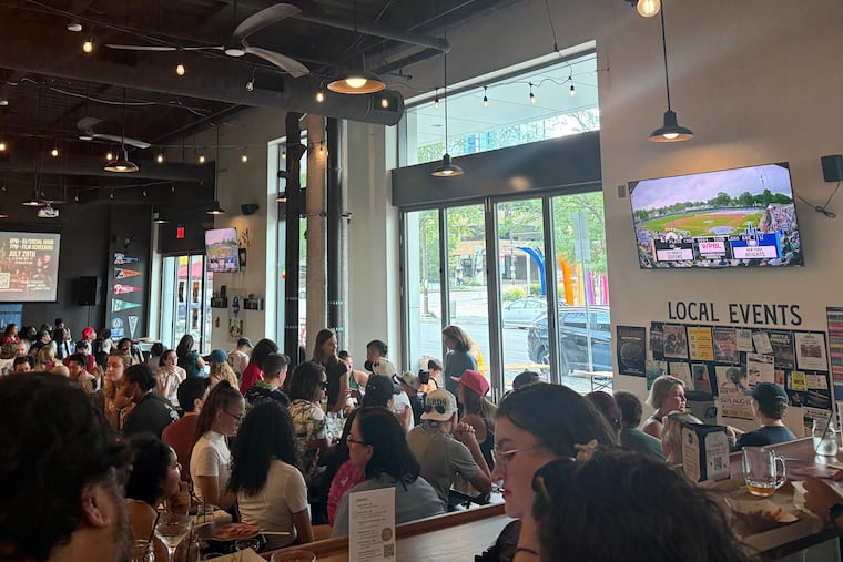 Fans gather at Two Locals to watch the first-ever Women's Pro Baseball League game on Saturday.