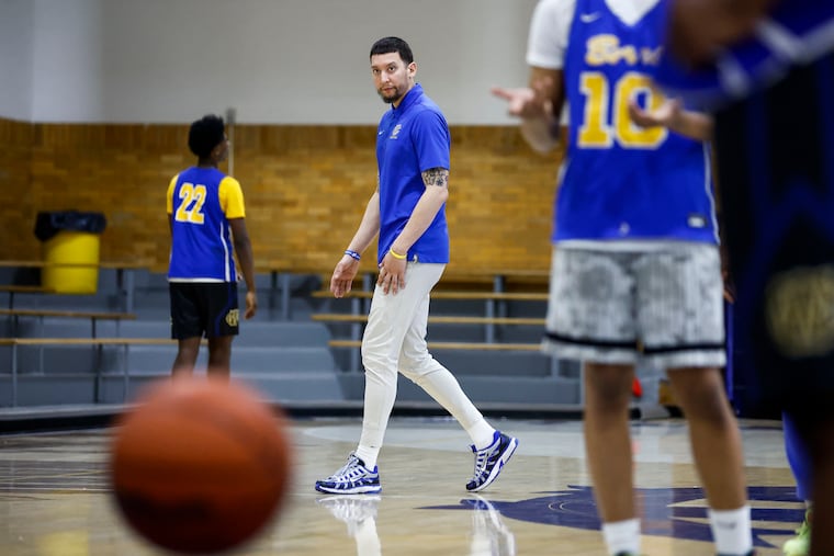 West Catholic basketball coach Miguel Bocachica, center, will step down after seven seasons with the Burrs, leading the team to a pair of state titles.