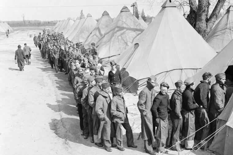 Men of the Civilian Conservation Corps, created during the Great Depression, entered a tent to receive canteens after getting their uniforms at Camp Dix, N.J., date unknown.